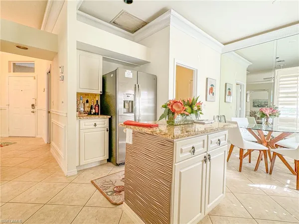 a large white kitchen with cabinets and chairs