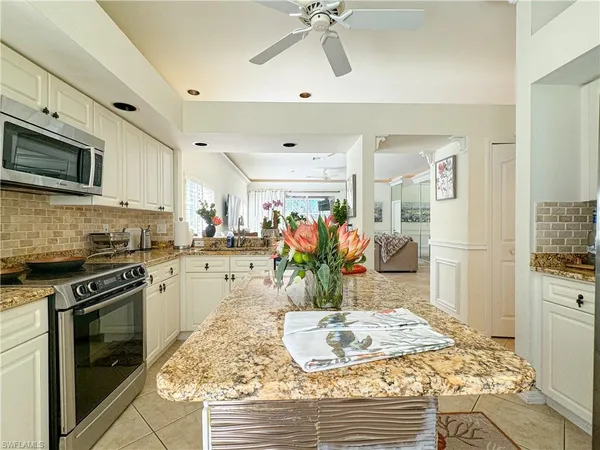 a kitchen with stainless steel appliances kitchen island granite countertop a sink and cabinets