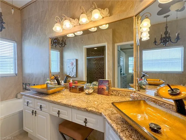 a bathroom with a granite countertop sink and a large mirror