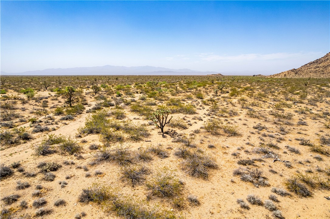0 East Arroyo Road Yucca, AZ 86438 - Photo 23 of 25 Expansive desert landscape featuring arid terrain, scattered brush, and distant mountains under a clear sky