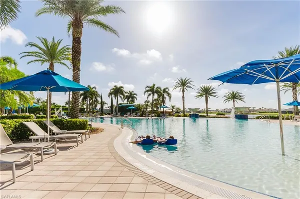 swimming pool with table and chairs under an umbrella