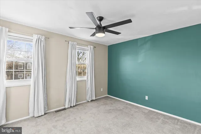 an empty room with a ceiling fan and a window