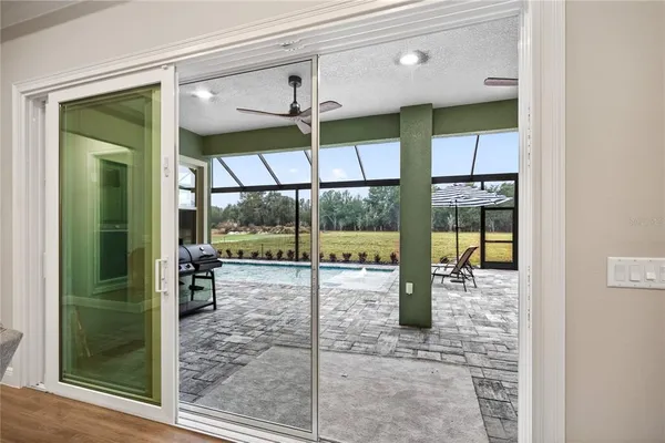 a swimming pool with outdoor seating and a large window