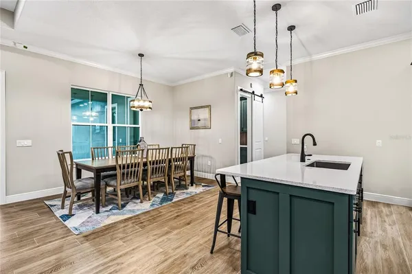 a view of a dining room and livingroom with furniture wooden floor a chandelier