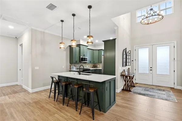a kitchen with kitchen island a sink appliances and cabinets