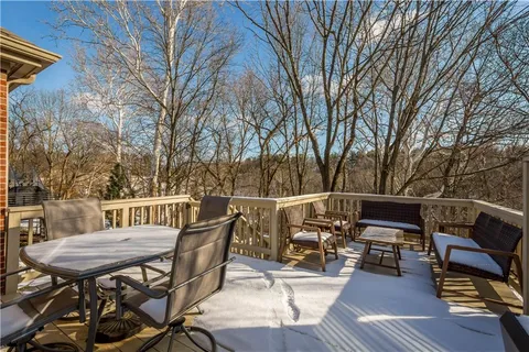 a view of a patio with table and chairs with wooden floor and fence