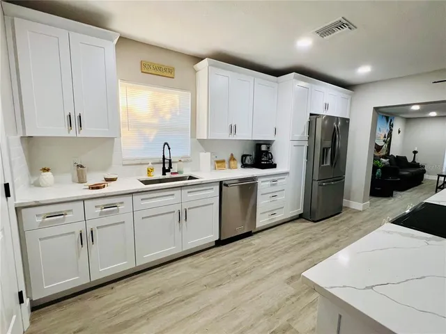 a kitchen with white cabinets and white appliances