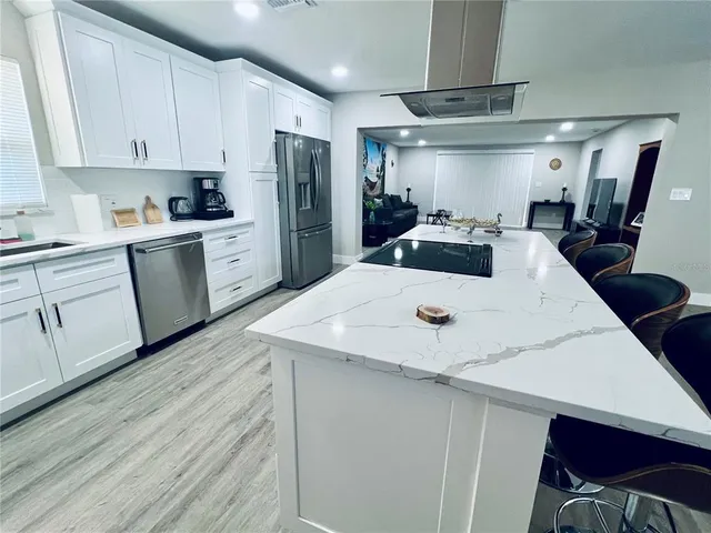 a kitchen with stainless steel appliances a refrigerator sink and cabinets