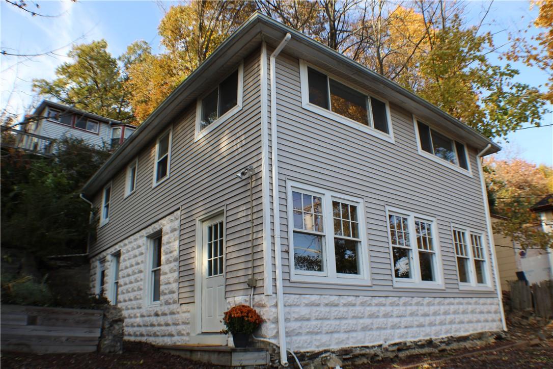 a front view of a house with a tree