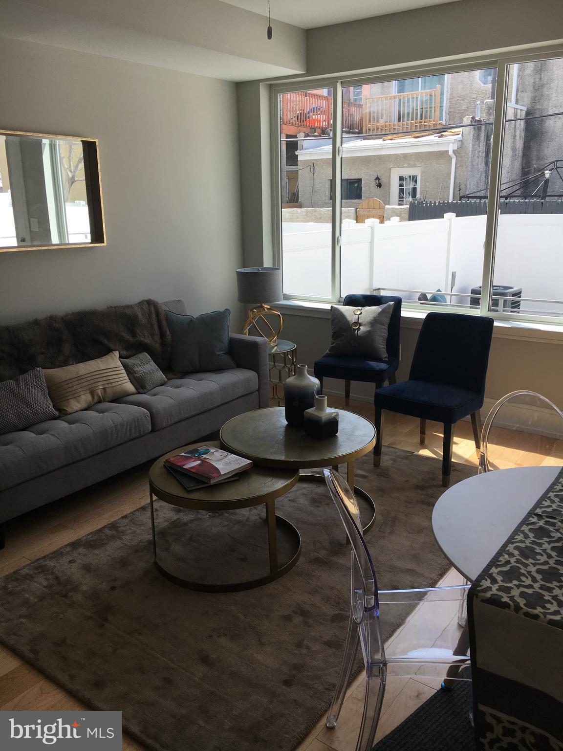 1008 South 17th Street, Unit A Philadelphia, PA 19146 - Photo 2 of 13 a living room with furniture wooden floor and a table