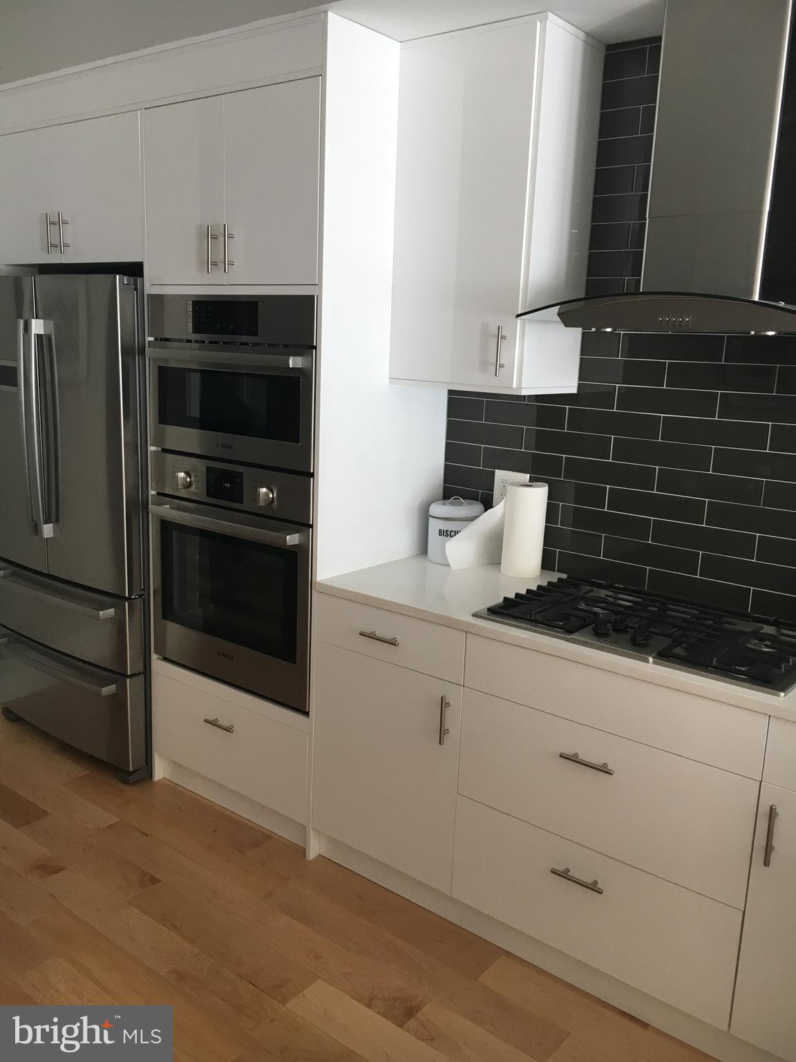 1008 South 17th Street, Unit A Philadelphia, PA 19146 - Photo 3 of 13 a kitchen with granite countertop a stove and a refrigerator