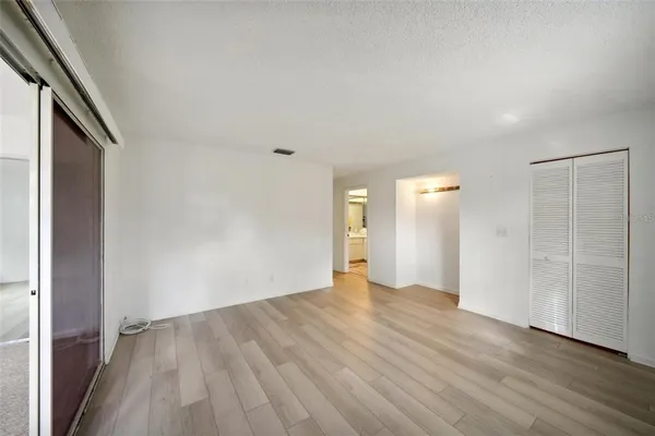 a view of an empty room with wooden floor