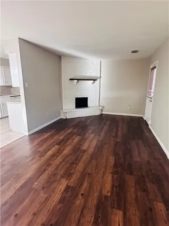an empty room with wooden floor and fireplace