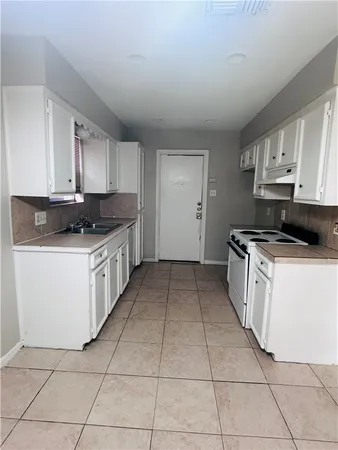 a kitchen with stainless steel appliances granite countertop a stove a sink and a white cabinets