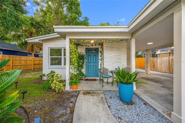 a view of a entryway door of the house with potted plants