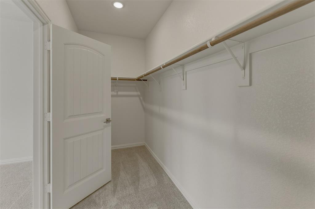 156 Oak Grv Way Springtown, TX 76082 - Photo 17 of 25 Spacious walk-in closet featuring light grey carpeting, white walls, and built-in shelving with hanging rods