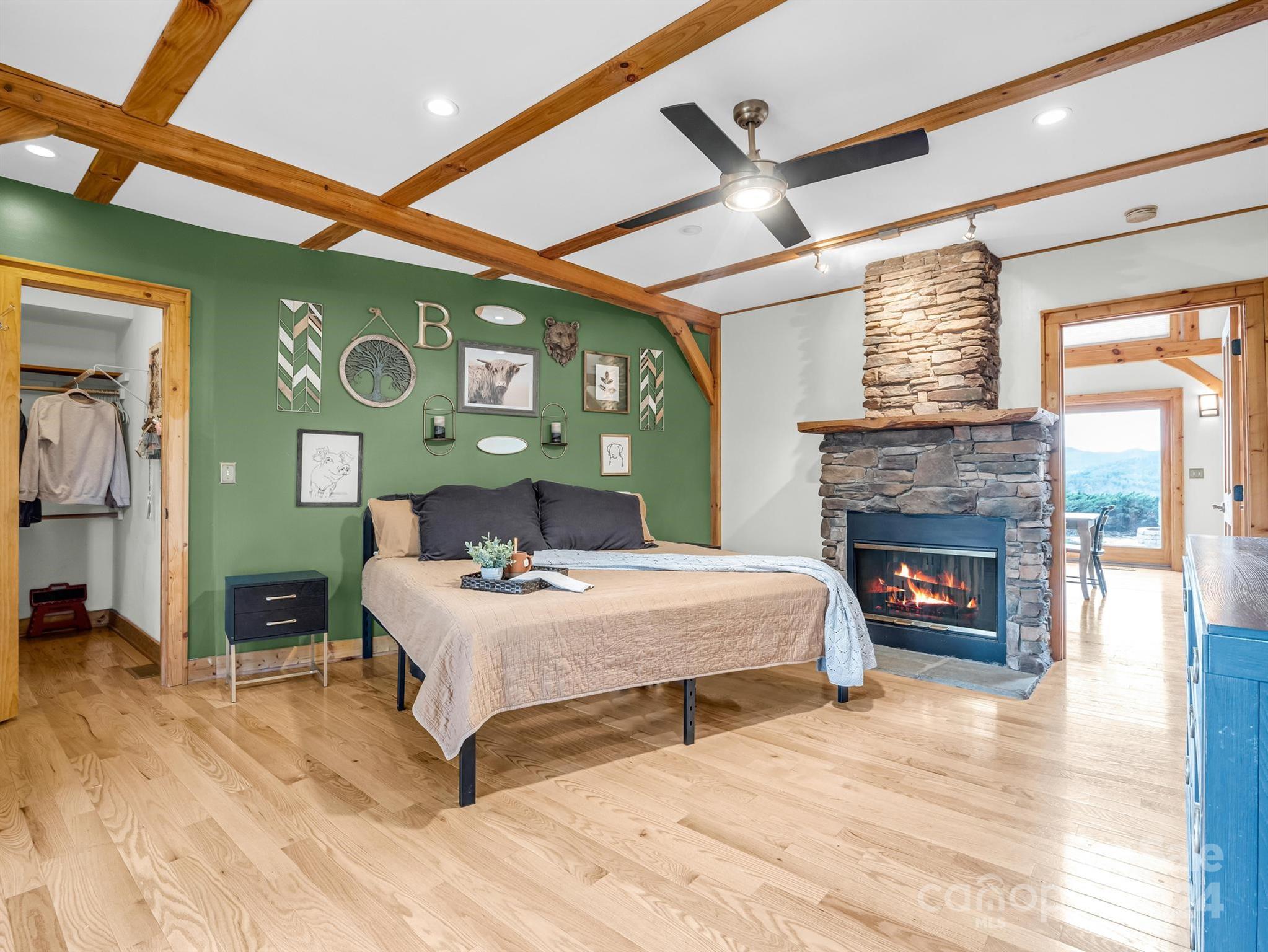 255 Oscar Young Road Mars Hill, NC 28754 - Photo 25 of 48 a bedroom with a bed and a fireplace