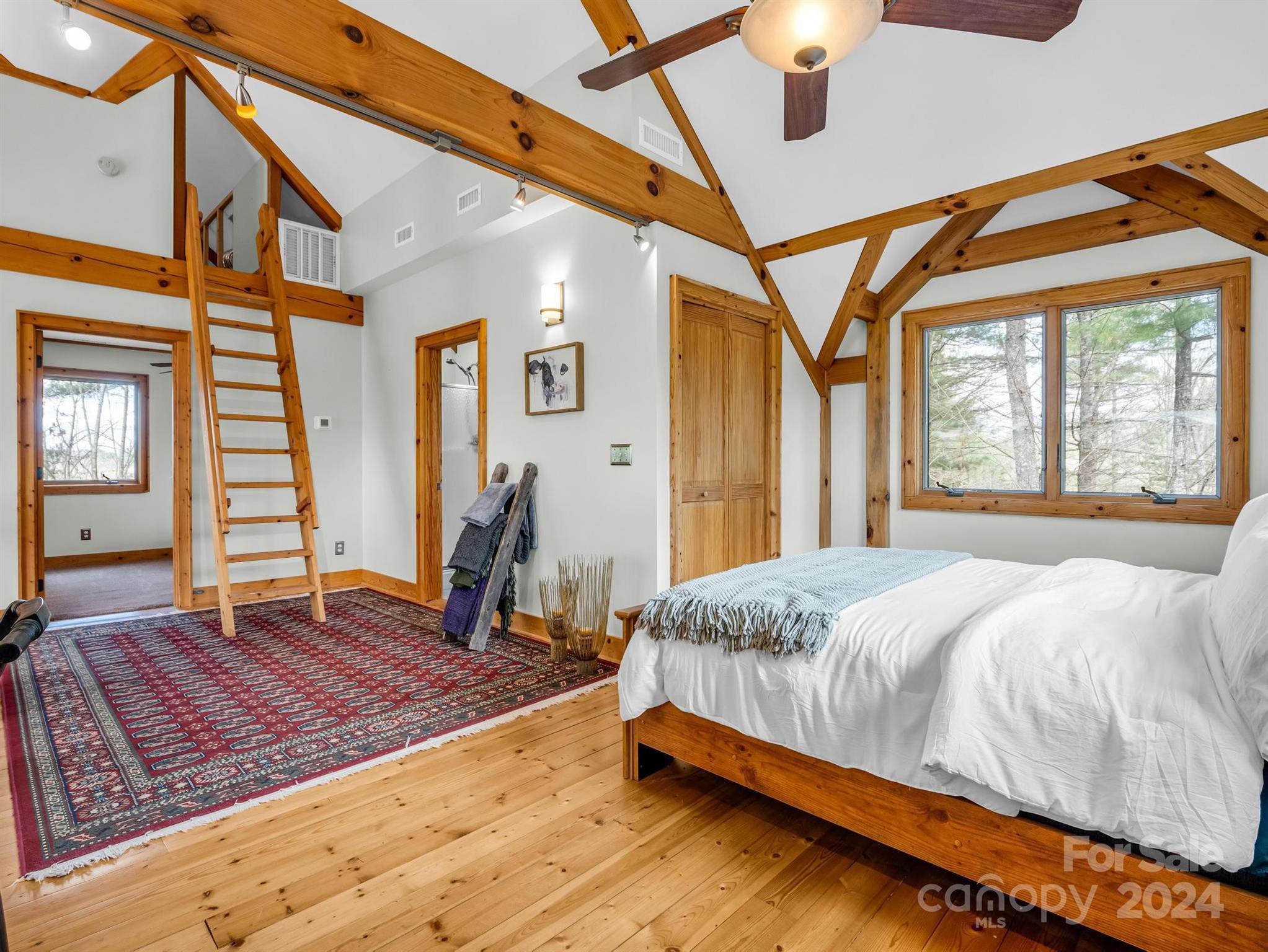 255 Oscar Young Road Mars Hill, NC 28754 - Photo 32 of 48 a bedroom with a bed and wooden floor