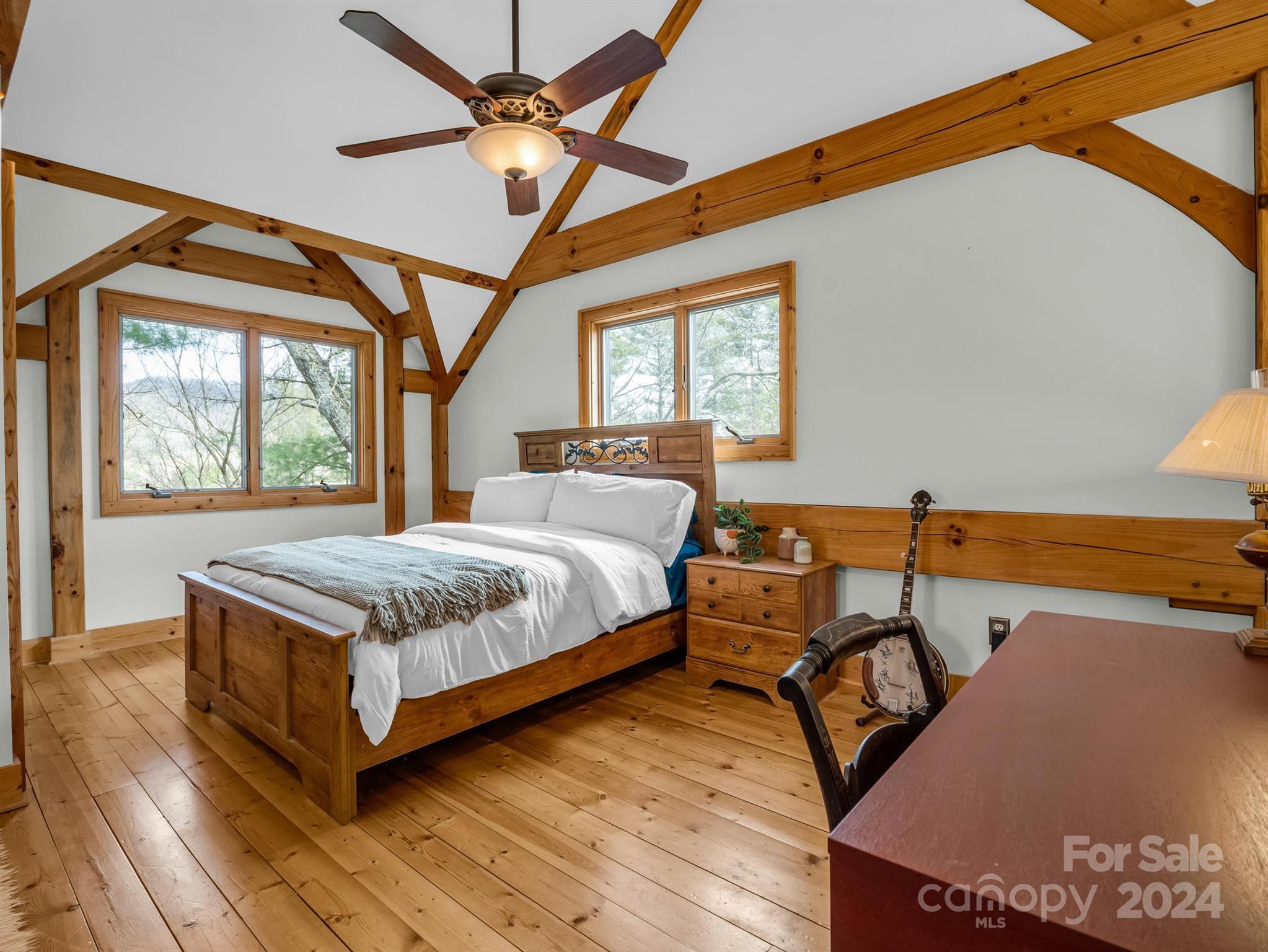 255 Oscar Young Road Mars Hill, NC 28754 - Photo 33 of 48 a bedroom with a bed a ceiling fan and a dresser next to a window