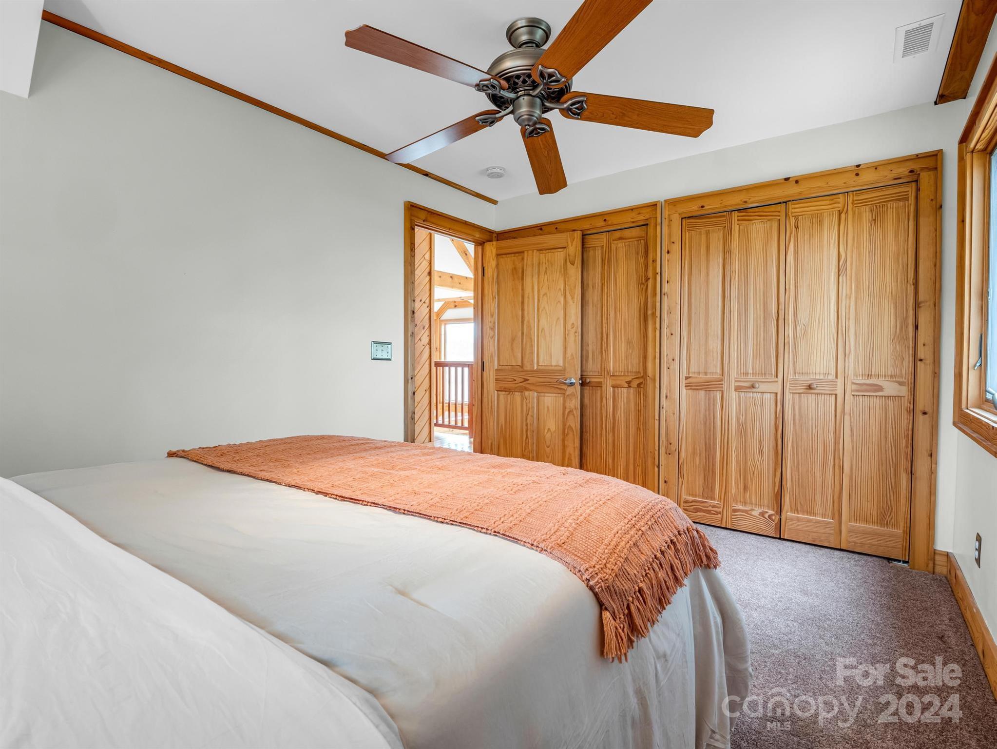 255 Oscar Young Road Mars Hill, NC 28754 - Photo 36 of 48 a bedroom with a bed and a chandelier