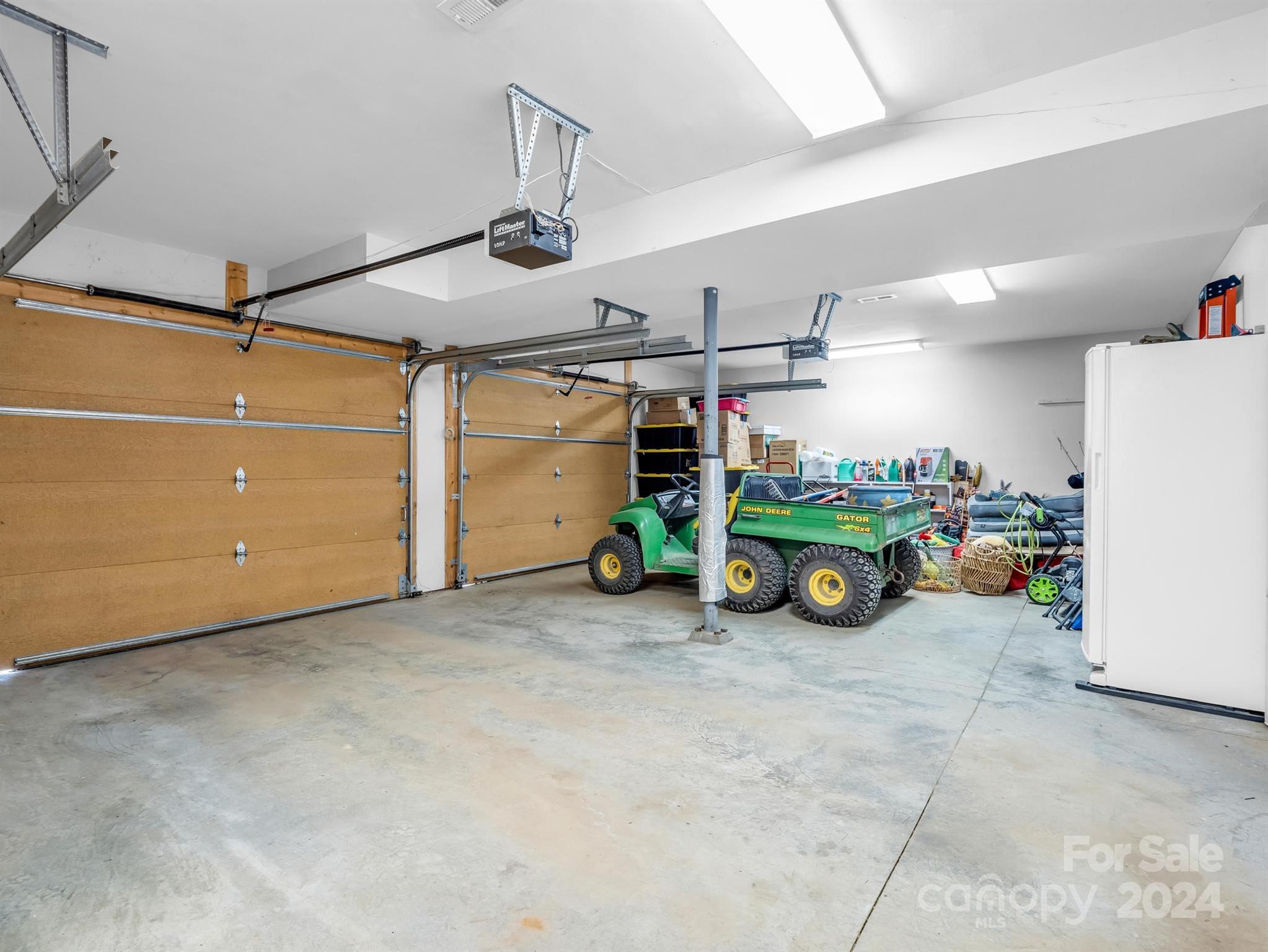 255 Oscar Young Road Mars Hill, NC 28754 - Photo 38 of 48 a view of a garage with a refrigerator and a car parked