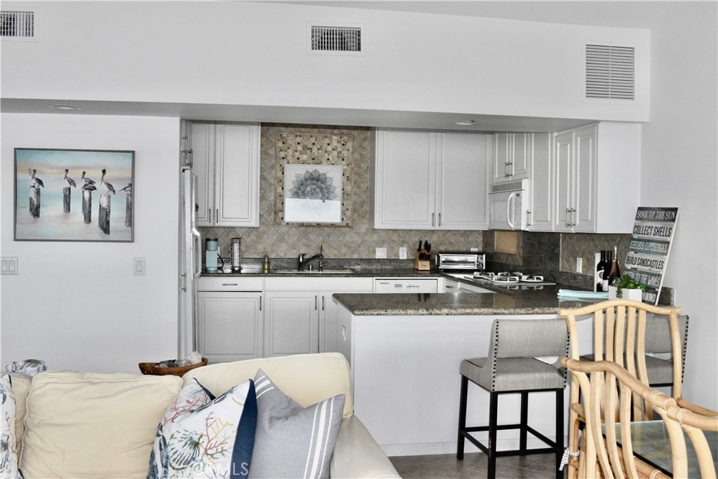 35605 Beach Road Dana Point, CA 92624 - Photo 12 of 55 a kitchen with a stove a sink and white cabinets