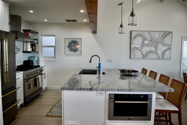 a kitchen with stainless steel appliances granite countertop a stove a sink and a microwave