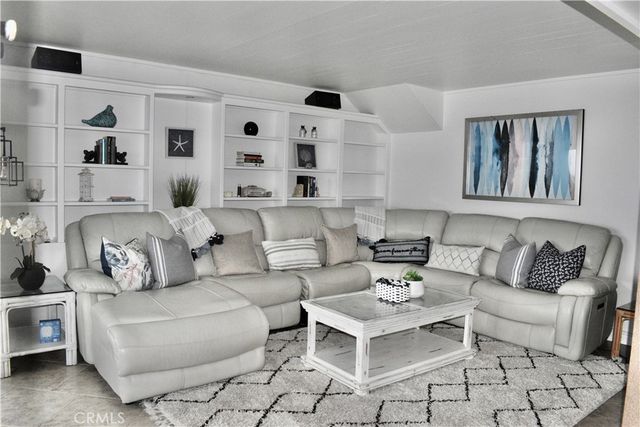 a living room with furniture and view of kitchen