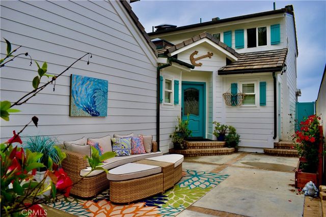 a front view of a house with outdoor seating and flowers