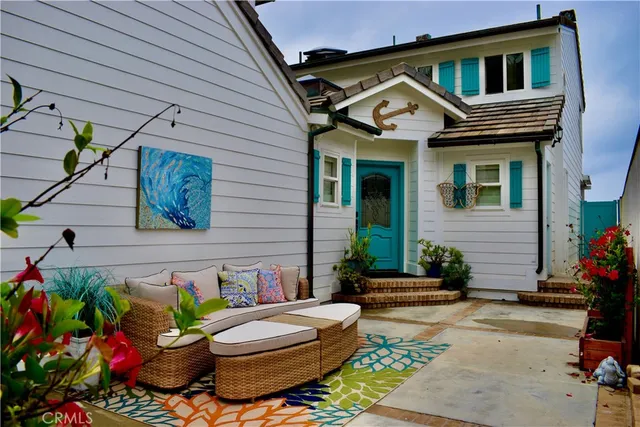 a front view of a house with outdoor seating and flowers