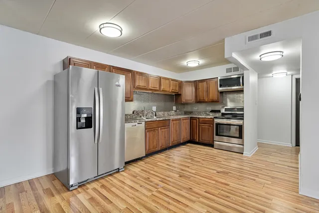 a kitchen with stainless steel appliances a refrigerator and a stove top oven