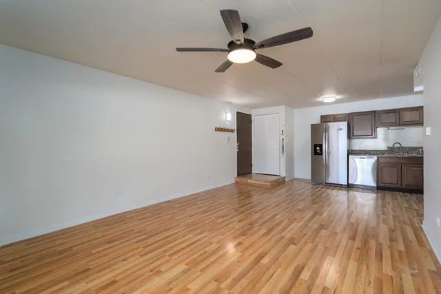 a view of a kitchen with a fridge and wooden floor
