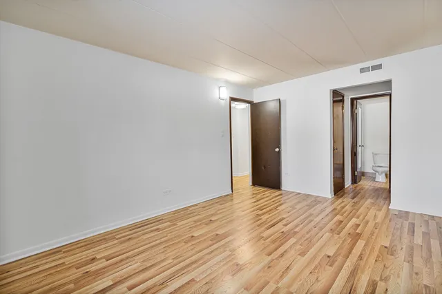 a view of an empty room with wooden floor