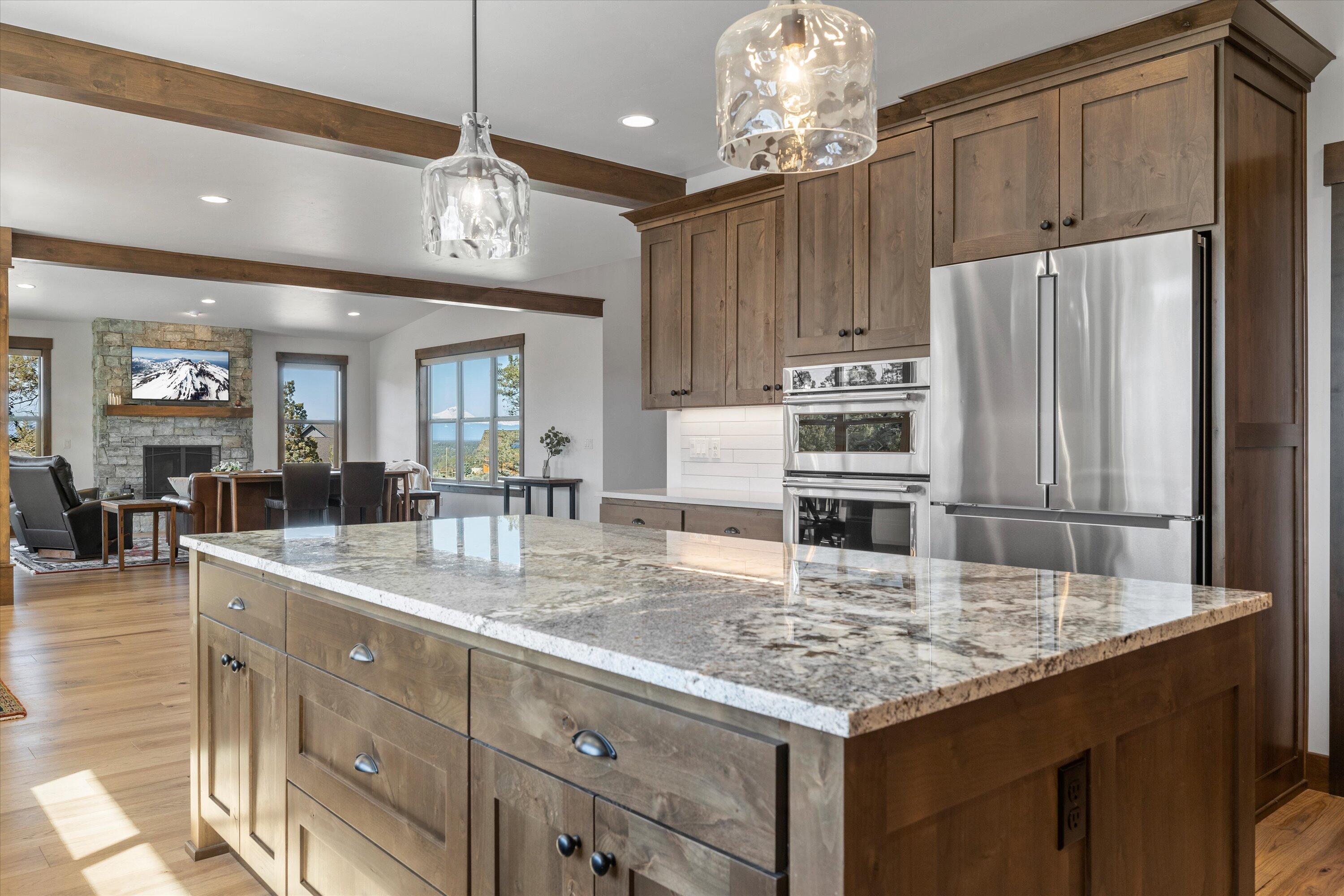 15687 Southwest Brasada Rnch Road Powell Butte, OR 97753 - Photo 25 of 73 a kitchen with kitchen island granite countertop a sink cabinets and refrigerator