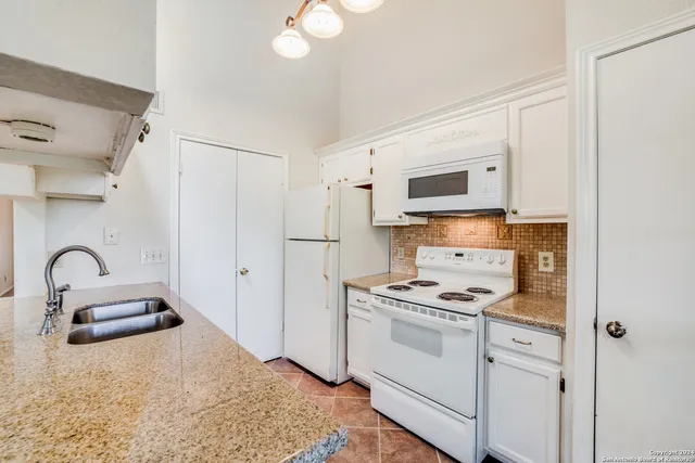 a kitchen with granite countertop a stove and a sink