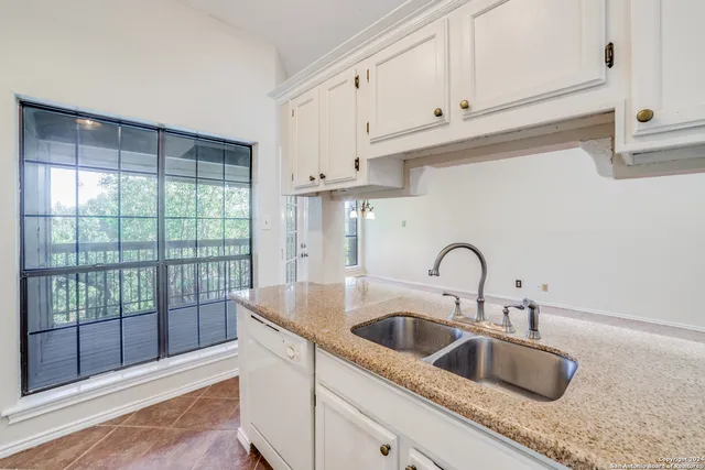 a kitchen with granite countertop a sink and cabinets