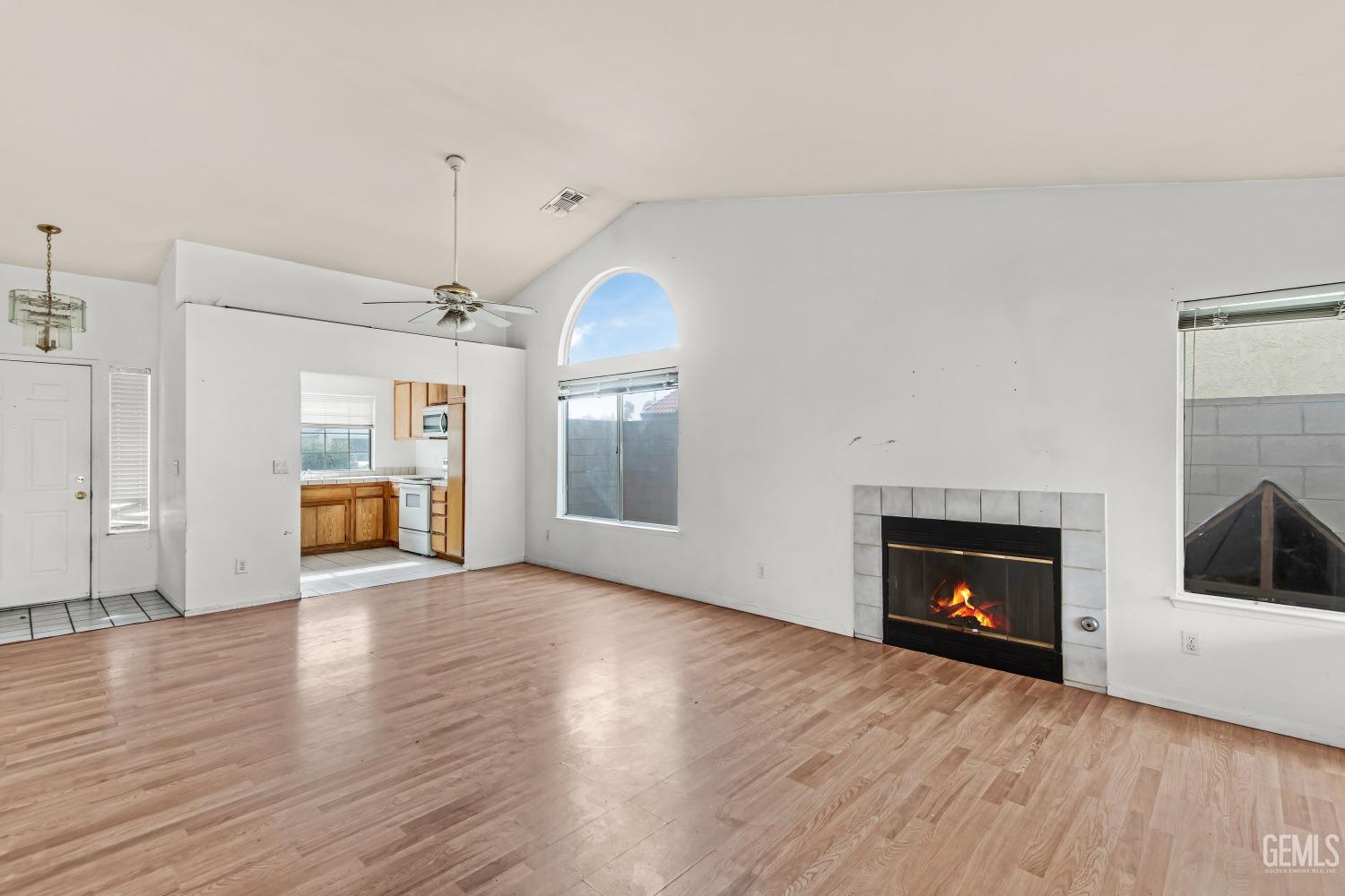 Undisclosed Address Bakersfield, CA 93313 - Photo 11 of 34 a view of an empty room with wooden floor fireplace and a window
