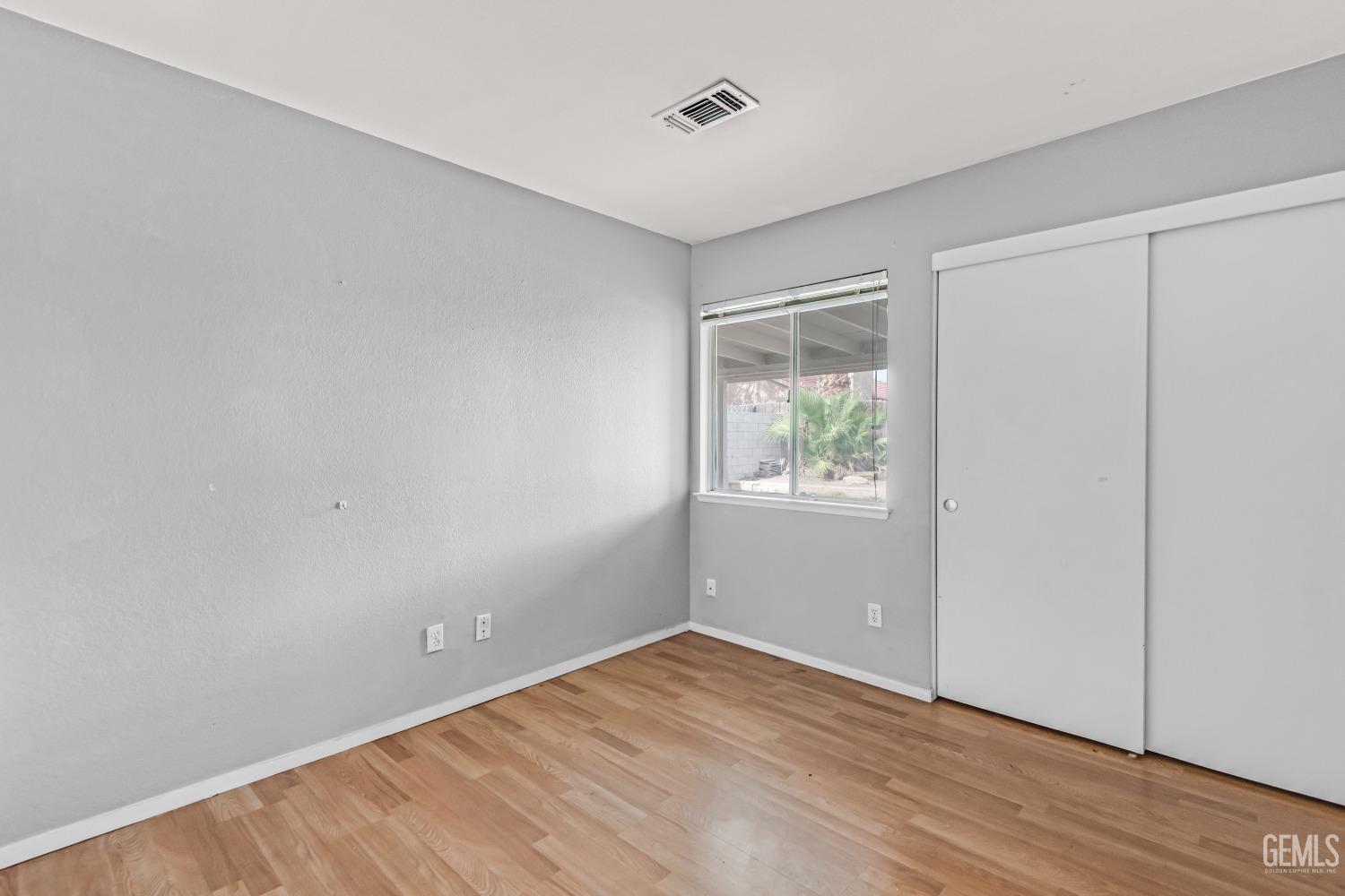 Undisclosed Address Bakersfield, CA 93313 - Photo 16 of 34 a view of an empty room with wooden floor and a window