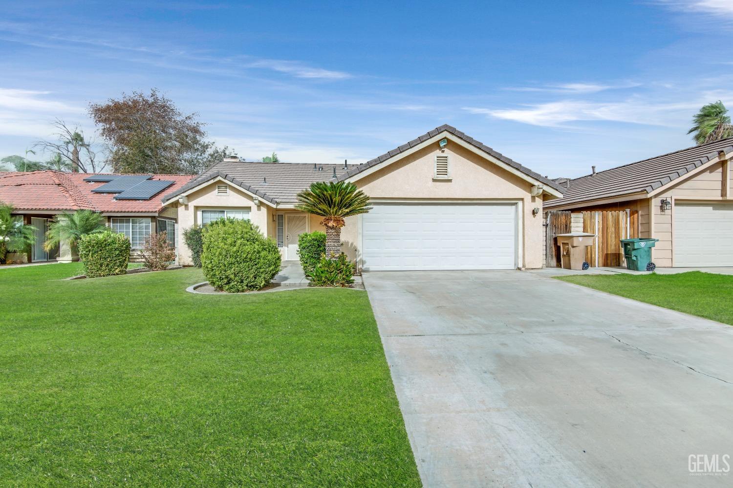 Undisclosed Address Bakersfield, CA 93313 - Photo 2 of 34 a front view of a house with a yard and garage