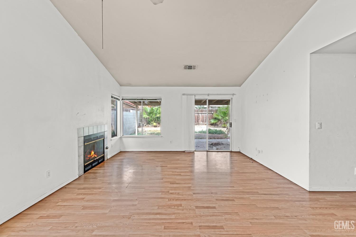 Undisclosed Address Bakersfield, CA 93313 - Photo 7 of 34 a view of an empty room with wooden floor and a window