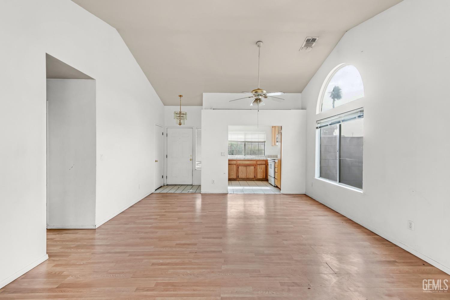 Undisclosed Address Bakersfield, CA 93313 - Photo 10 of 34 an empty room with wooden floor fan and windows