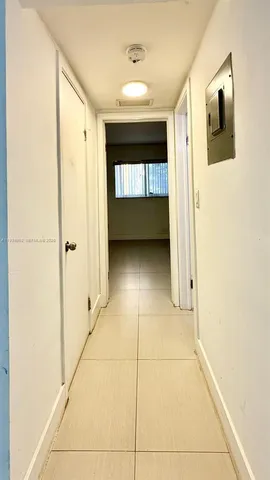 a view of a hallway with wooden floor and a cabinet