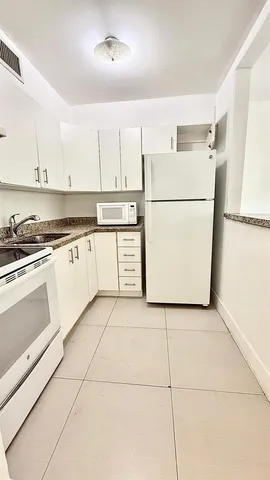 a kitchen with a refrigerator sink stove and cabinets