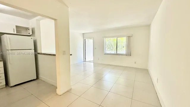a view of a kitchen with a sink and a refrigerator