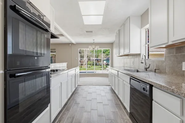 a kitchen with stainless steel appliances granite countertop a sink a stove and a refrigerator
