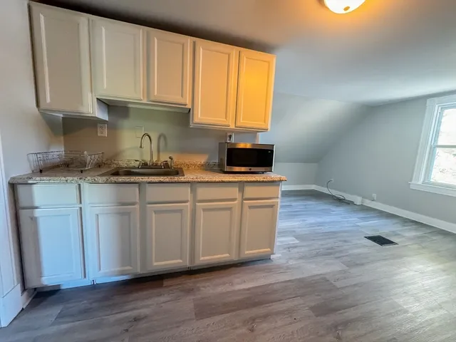 a kitchen with stainless steel appliances granite countertop a sink a stove a microwave and cabinets