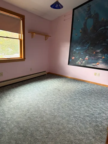 a view of a room with wooden floor and a window