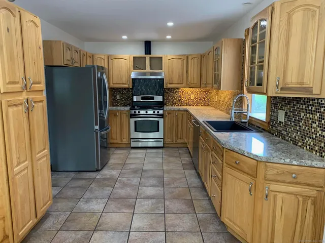 a kitchen with granite countertop a refrigerator and a sink