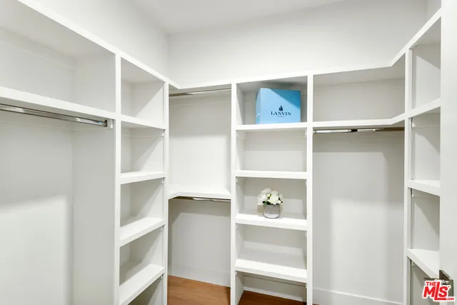 a view of walk in closet with empty racks