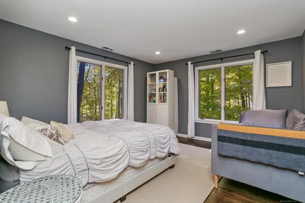 a bedroom with a bed and a large window
